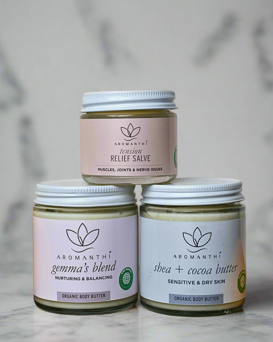 a natural backdrop with Aromanthi's gemma's blend, tension relief pain salve, and shea + cocoa butter which are all EWG verified