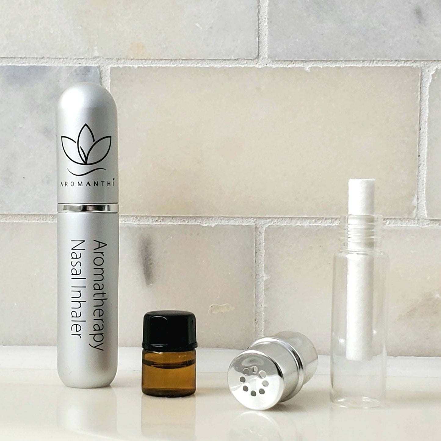 Aromanthi's aromatherapy nasal inhaler comes displayed with the aluminum eco-friendly tube, a glass inhaler insert, your essential oil blend of choice, and a cotton wick