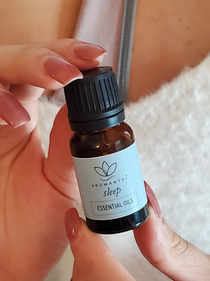 A close up photo of a woman holding the 10ml sleep essential oil blend